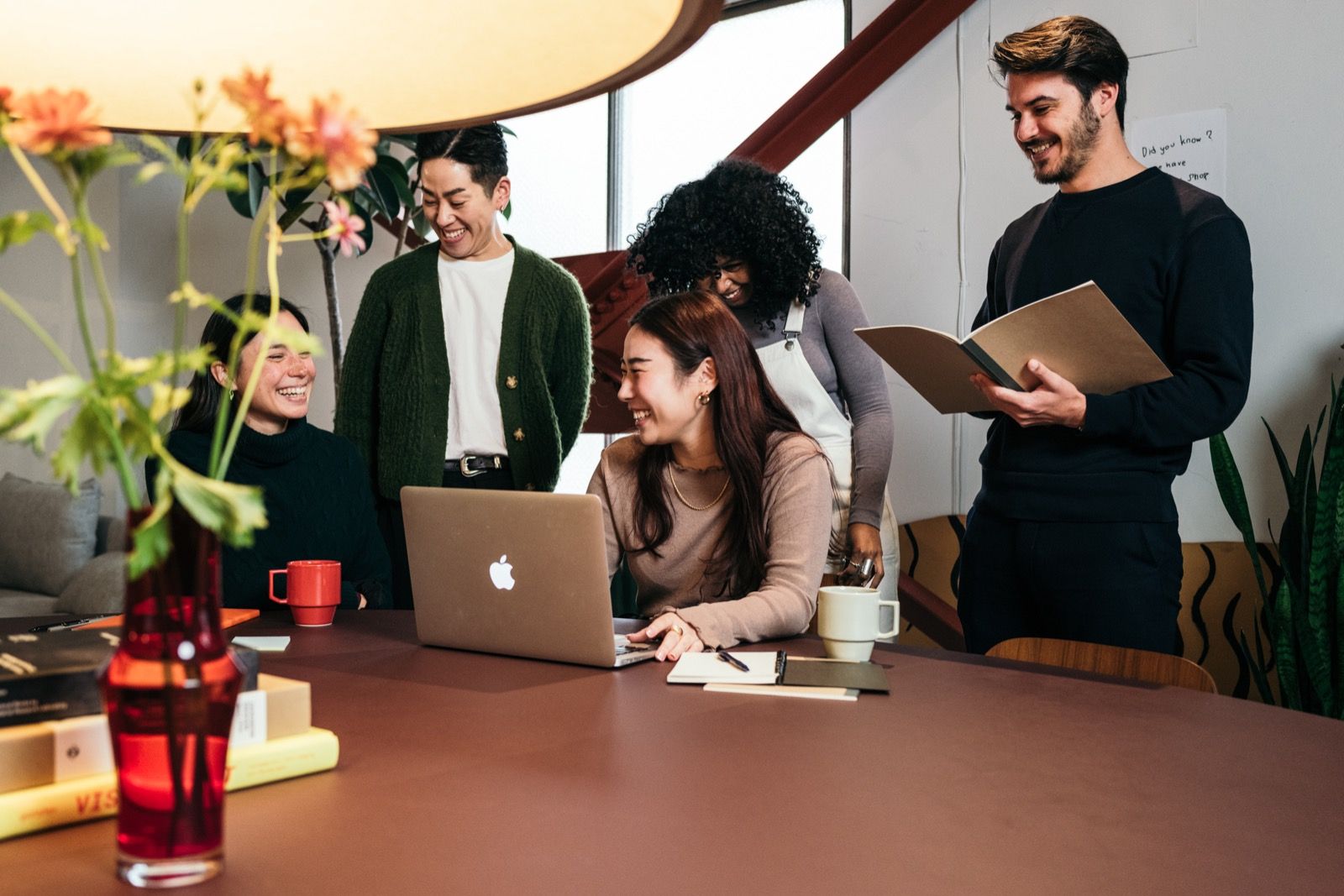 A small, diverse group in warm conversation around a shared table