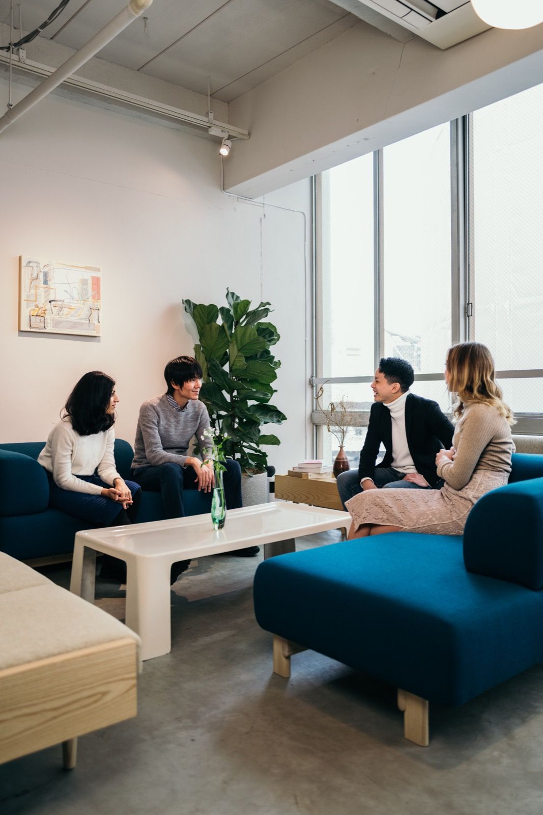 Colleagues in conversation in a sunlit lounge
